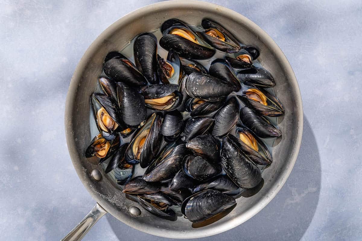 The mussels for the seafood salad in a skillet.