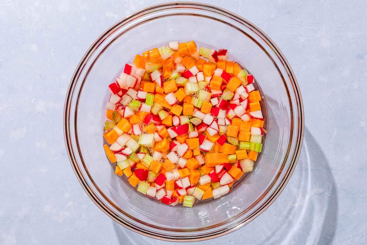 The chopped quick pickled vegetables for the seafood salad in a mixing bowl.