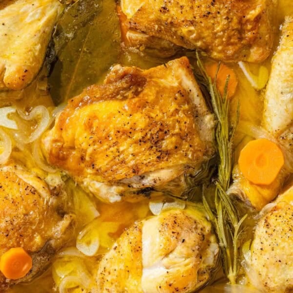 A close up of escabeche de pollo in a skillet.