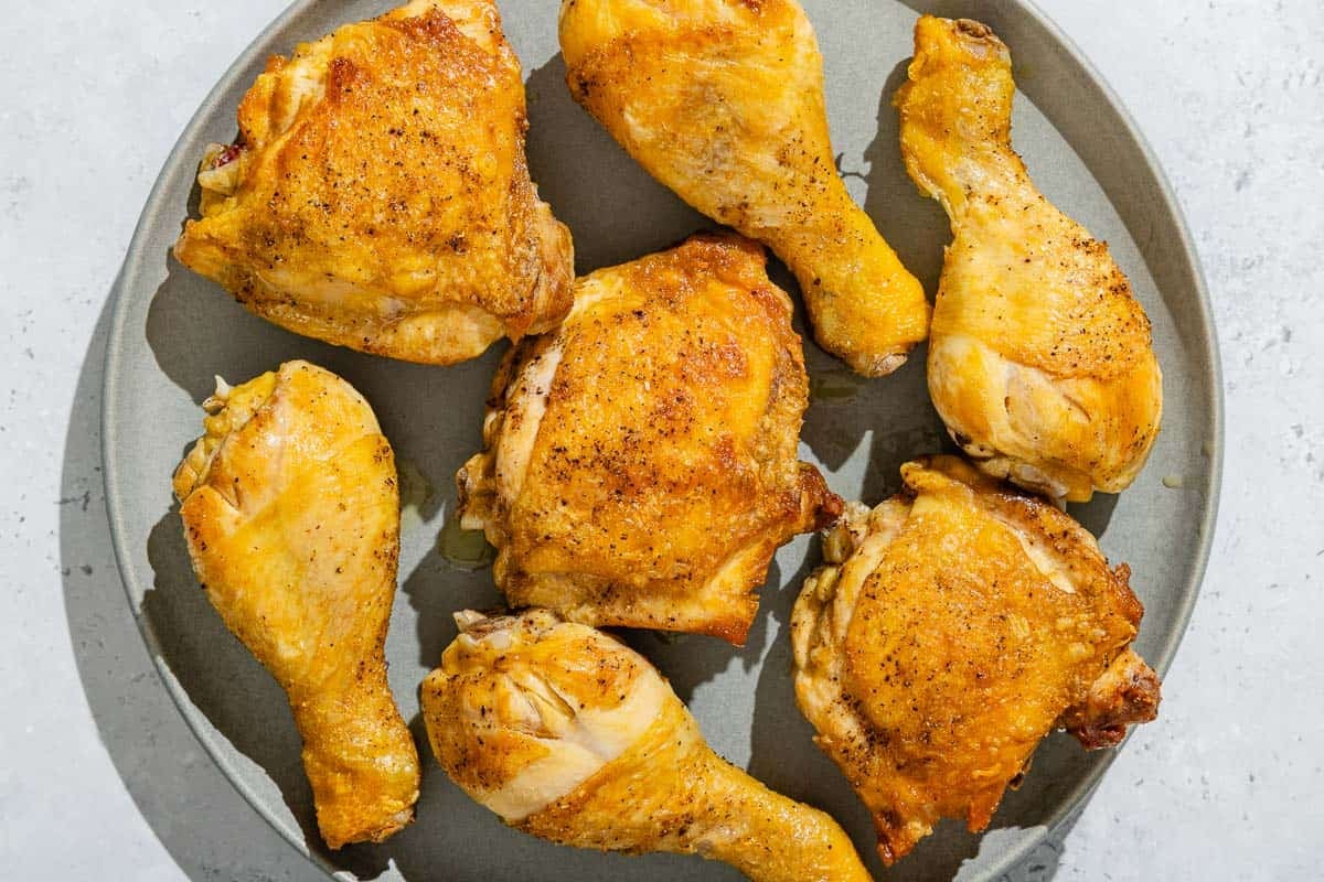 The browned chicken pieces for the escabeche de pollo on a plate.