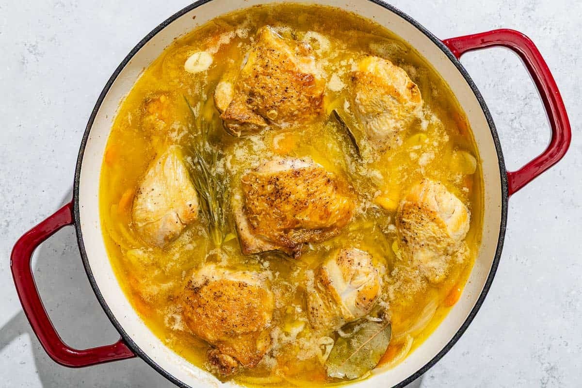 Escabeche de pollo simmering in a skillet.