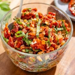 Sun dried tomato salsa in a bowl with a spoon.