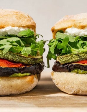 Two roasted vegetable sandwiches sitting side-by-side.