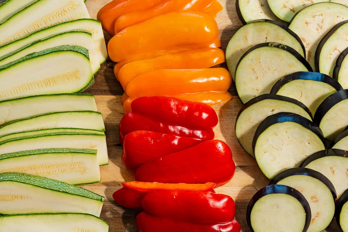 The sliced vegetables for the roasted vegetable sandwich recipe on a wooden cutting board.