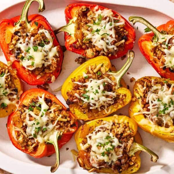 Several grilled stuffed peppers on a serving platter.