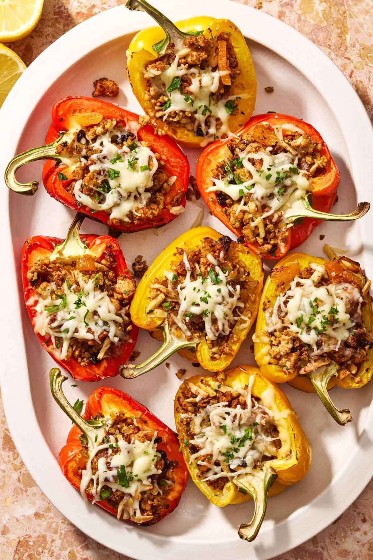 Several grilled stuffed peppers on a serving platter.