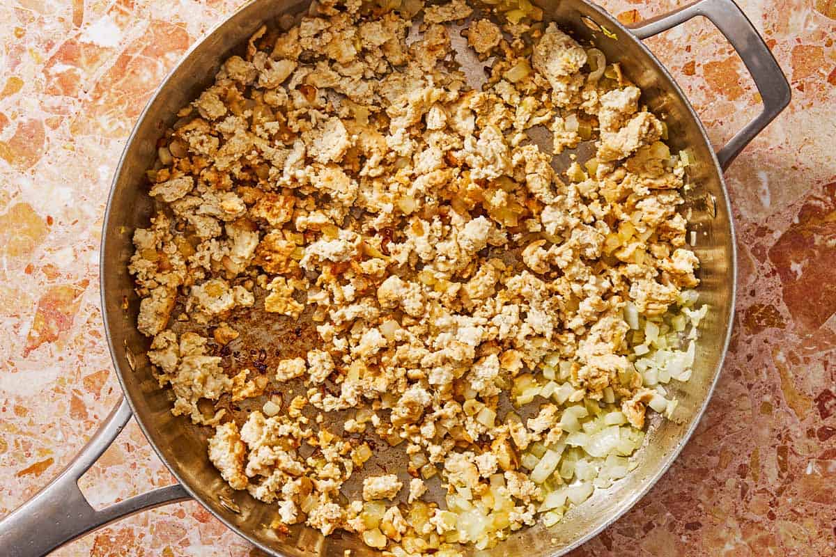 The aromatics and the ground chicken for the grilled stuffed peppers in a tall sided skillet.