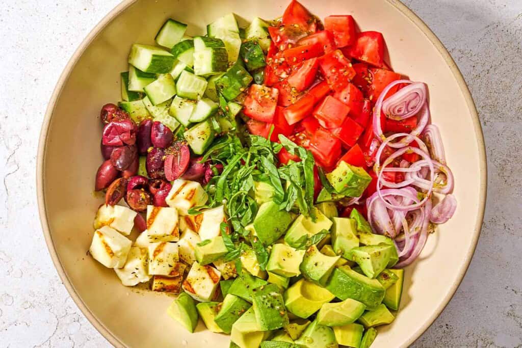 The ingredients for the avocado salad in a serving bowl just before being mixed together.