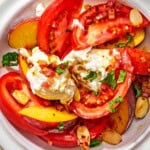 A serving of the peach burrata salad on a plate.