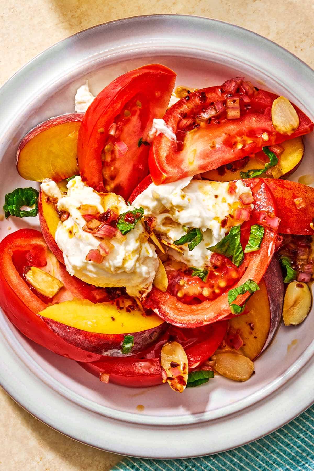 A serving of the peach burrata salad on a plate.