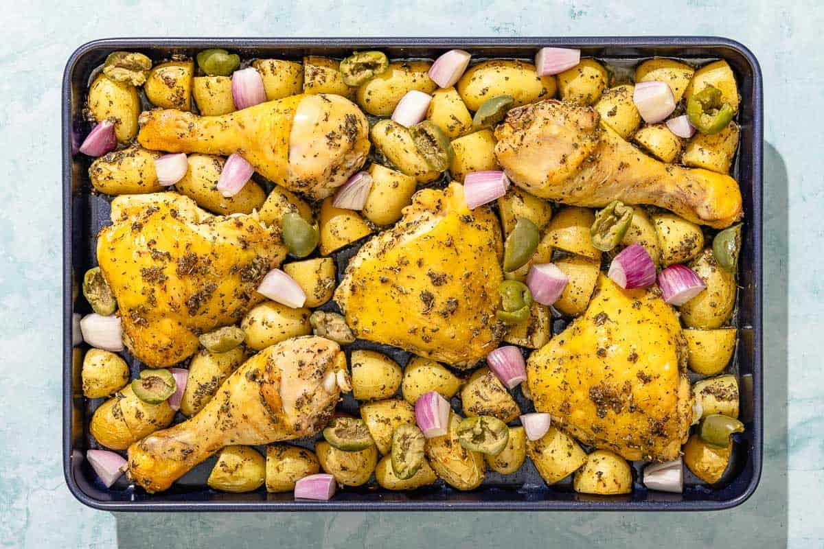 The uncooked chicken and potatoes recipe on a sheet pan.
