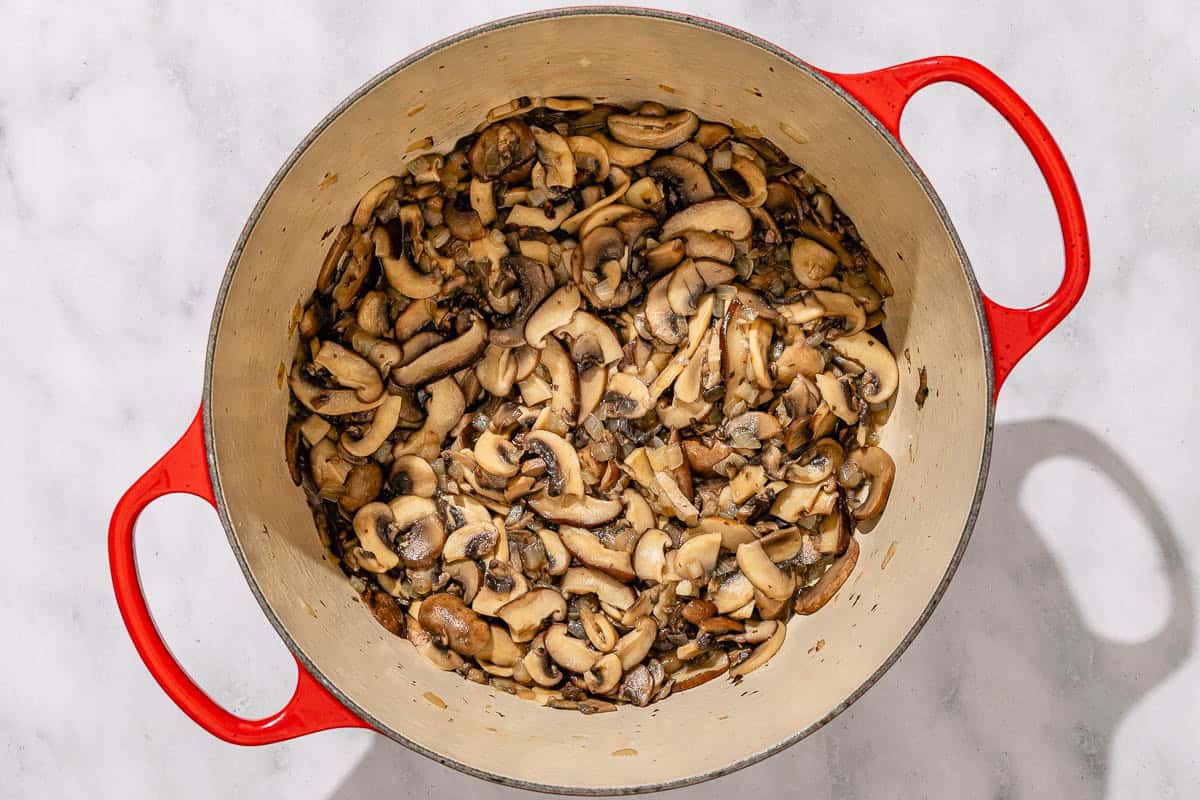 Sliced mushrooms in a pot after they have been sautéed.