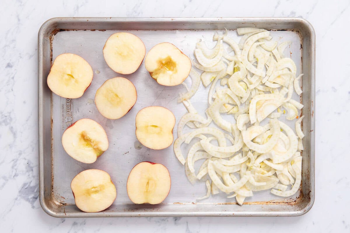 The the uncooked apples and sliced fennel for the butternut squash apple soup on a sheet pan.