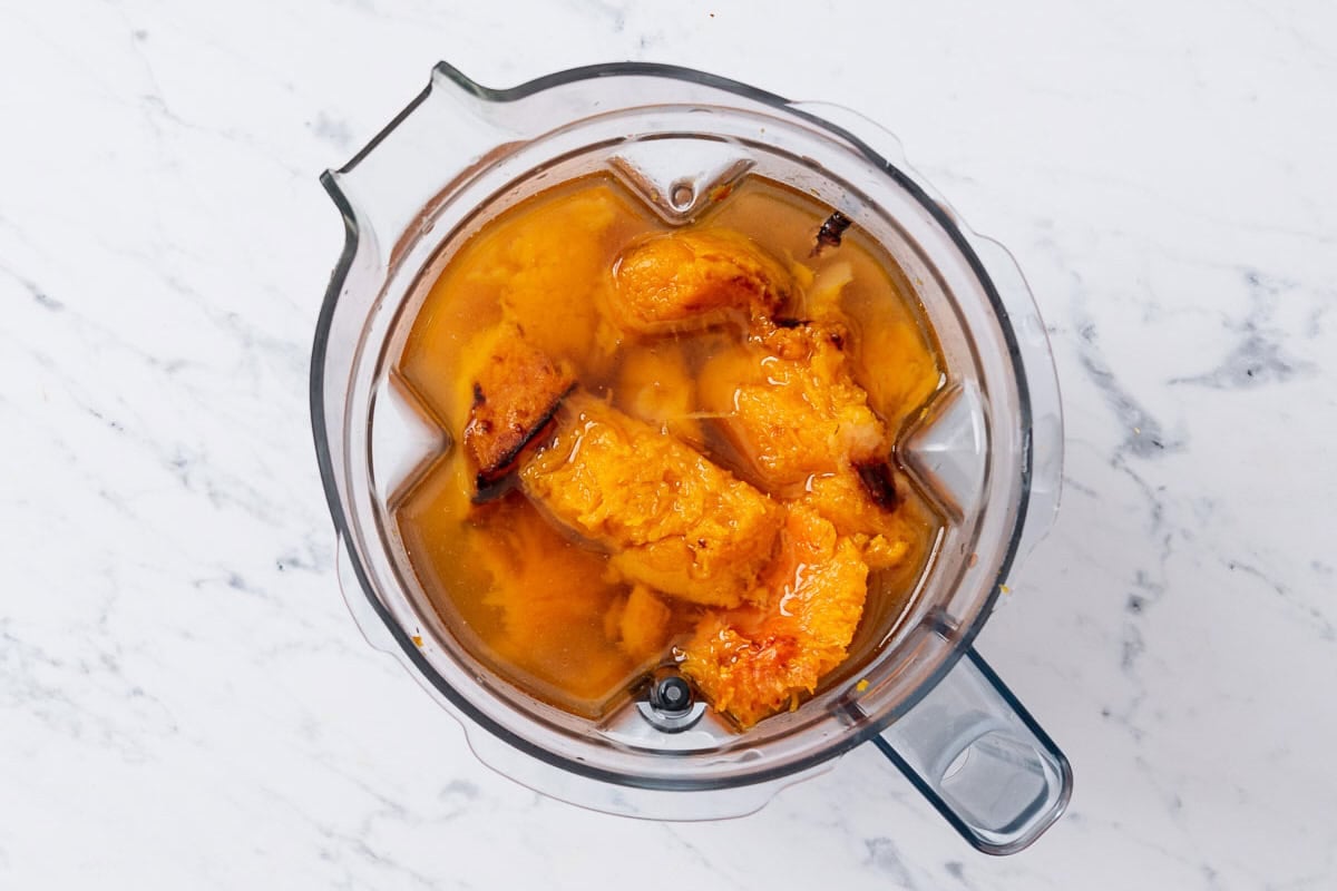 The roasted vegetables for the butternut squash apple soup in the pitcher of a blender just before being mixed together.
