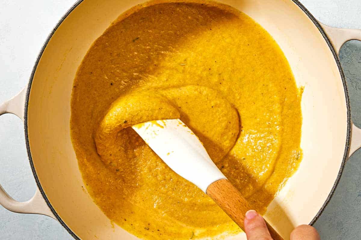 The butternut squash sauce for the butternut squash pasta being stirred in a pot with a spatula.