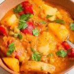 Vegetable stew in a bowl with a spoon.