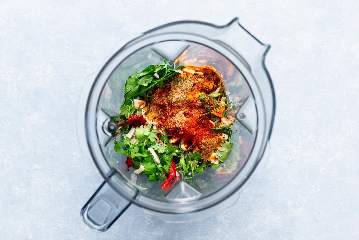 The ingredients for the red chermoula in the bowl of a blender just before being mixed together.