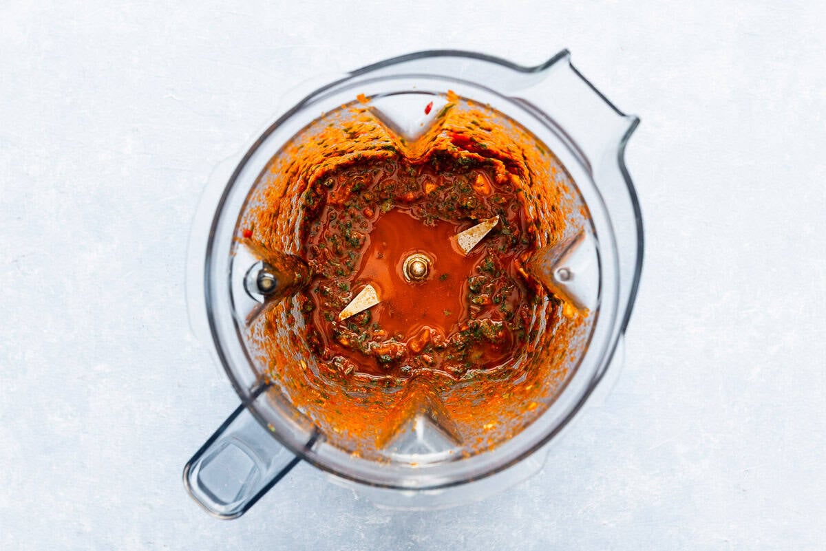 The ingredients for the red chermoula in the bowl of a blender just after being mixed together.
