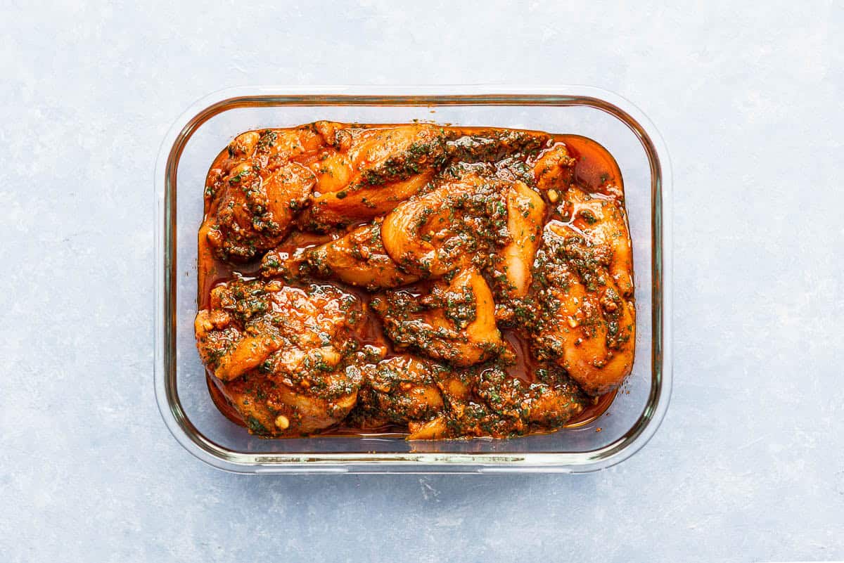 The chicken breasts for the chicken chermoula marinating in a glass baking dish.