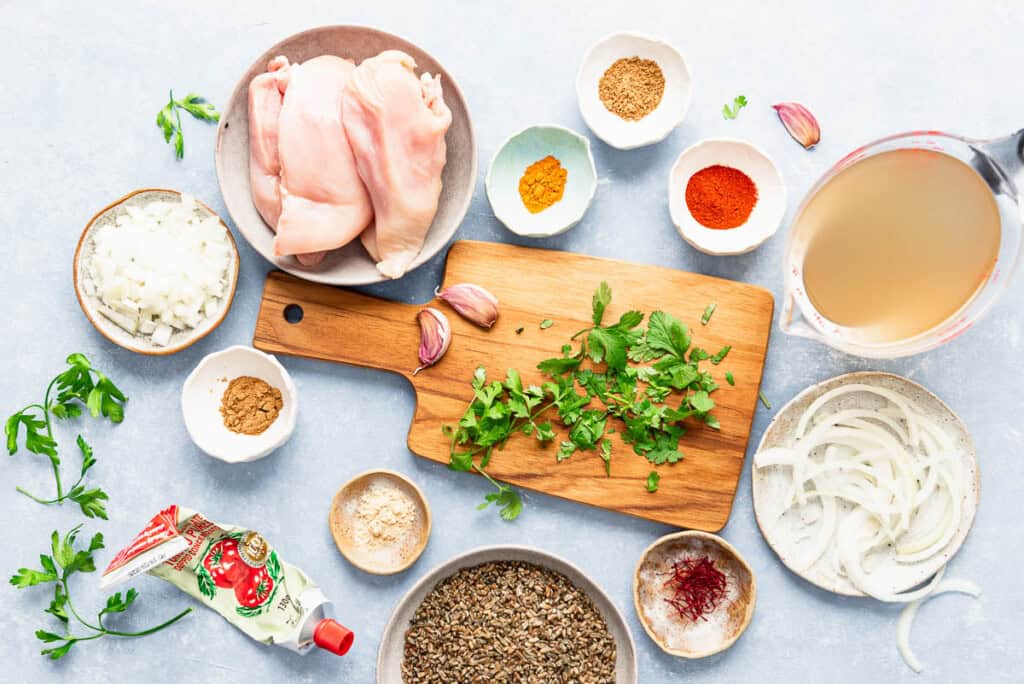 Ingredients for chermoula chicken including chicken breasts, olive oil, onion, kalamata olives, freekeh, salt, black pepper, ground cinnamon, saffron, preserved lemon pulp, garlic, cilantro, parsley, tomato paste, cumin, coriander, paprika, turmeric, ginger, and red pepper flakes.
