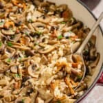 Mushroom rice in a skillet with a serving spoon.