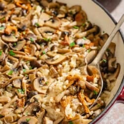 Mushroom rice in a skillet with a serving spoon.