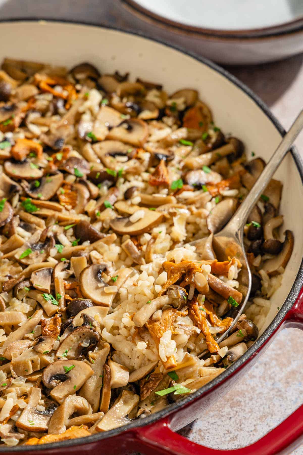 Mushroom rice in a skillet with a serving spoon.