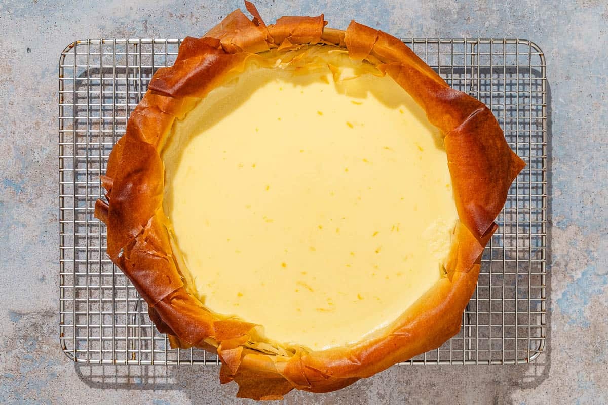 The baked baklava cheesecake being cooled on a wire rack.