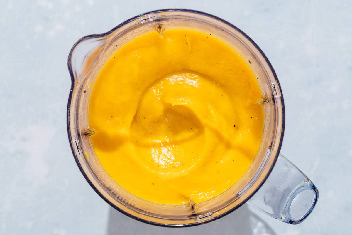 The ingredients for the butternut squash pasta sauce in the pitcher of a blender just after being mixed together.
