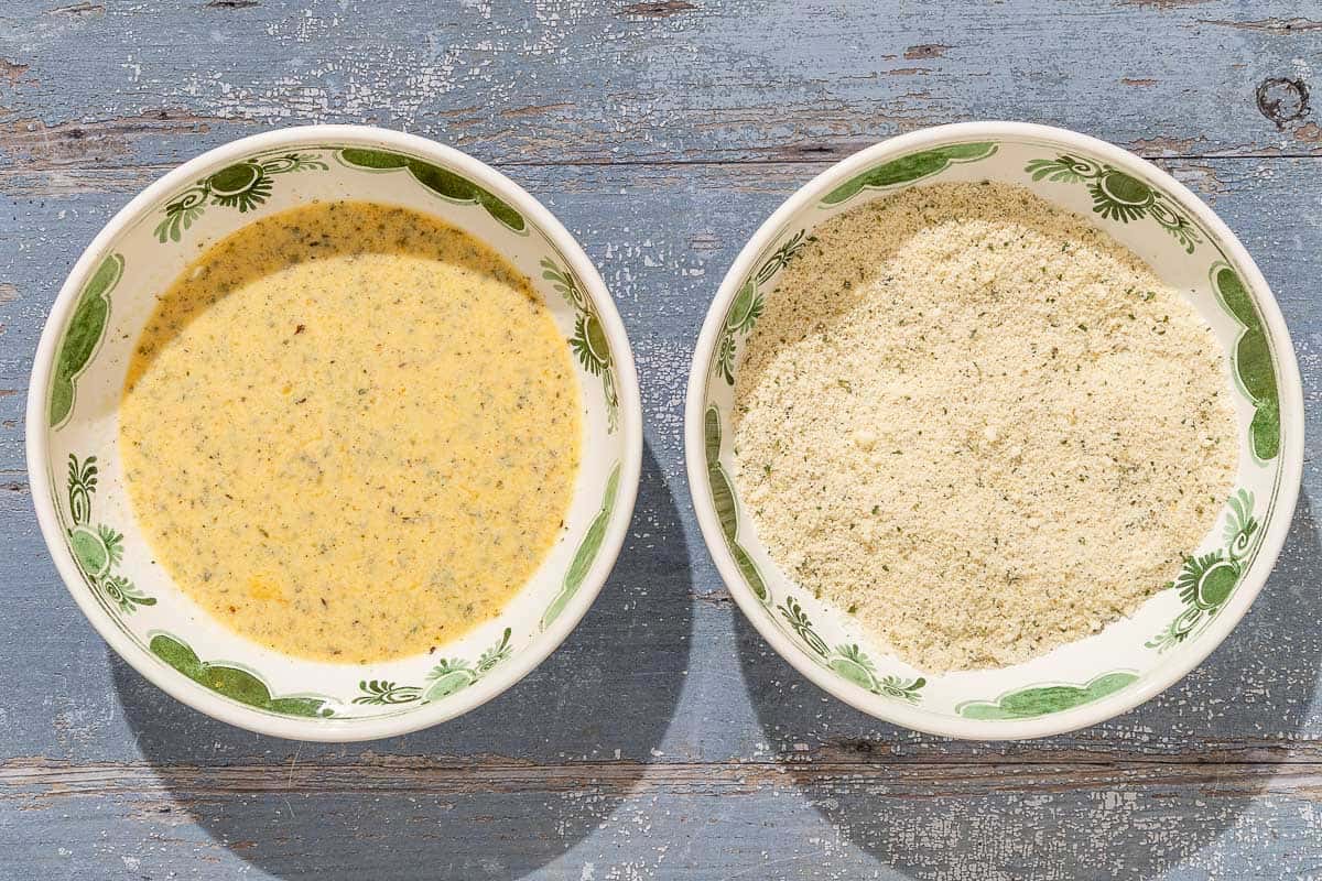 The batter and breadcrumb topping for the baked cauliflower parmesan in 2 bowl.