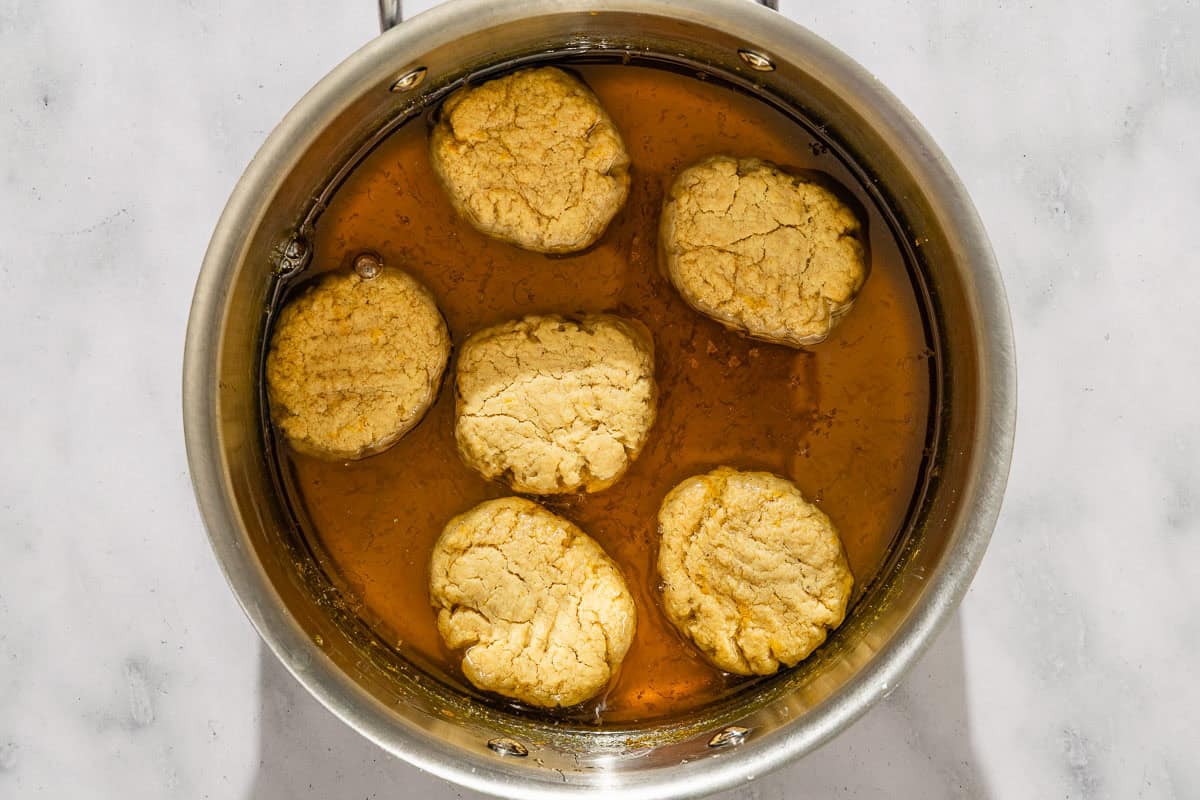 The melomakarona soaking in the syrup in a pot.