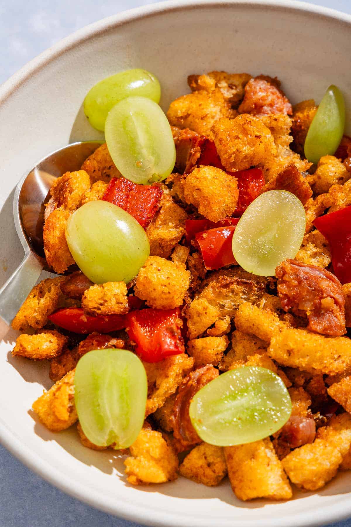 A serving of migas in a bowl with a spoon.