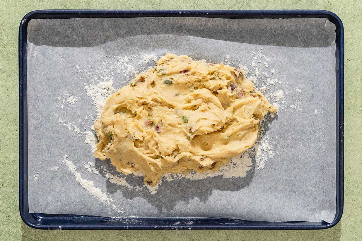 The dough for the pistachio biscotti on a parchment lined sheet pan.