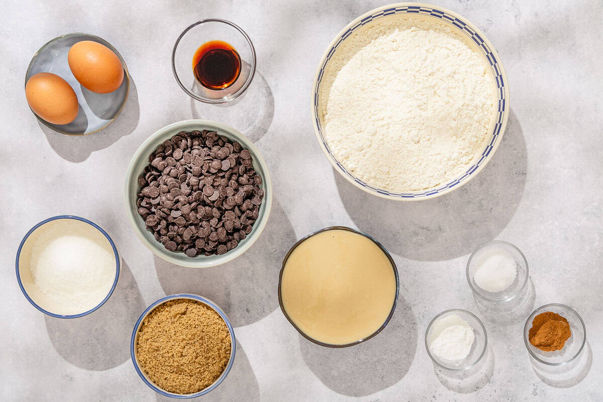 Ingredients for the tahini chocolate chip cookies including tahini, sugar, brown sugar, eggs, vanilla extract, salt, baking soda, cinnamon, flour, and chocolate chips.