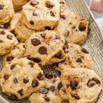 Several tahini chocolate chip cookies on a platter next to a kitchen towel. - 16