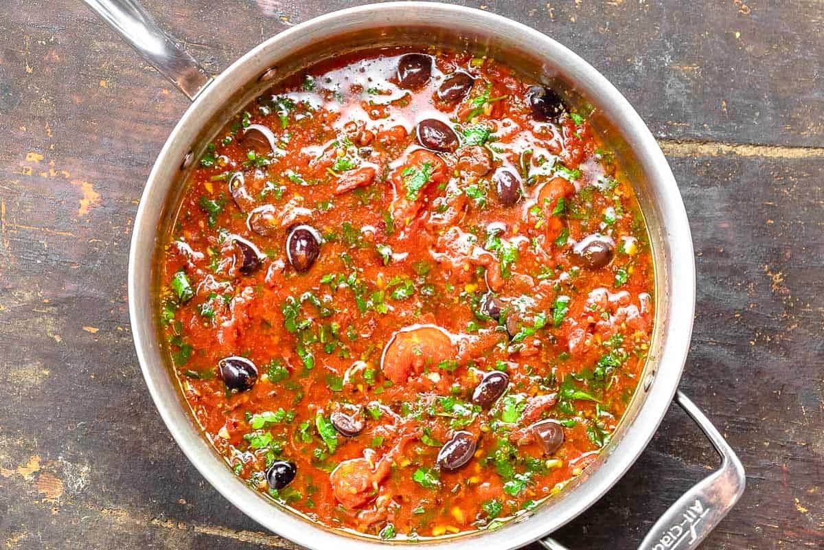 The sauce for the puttanesca recipe in a tall sided skillet.