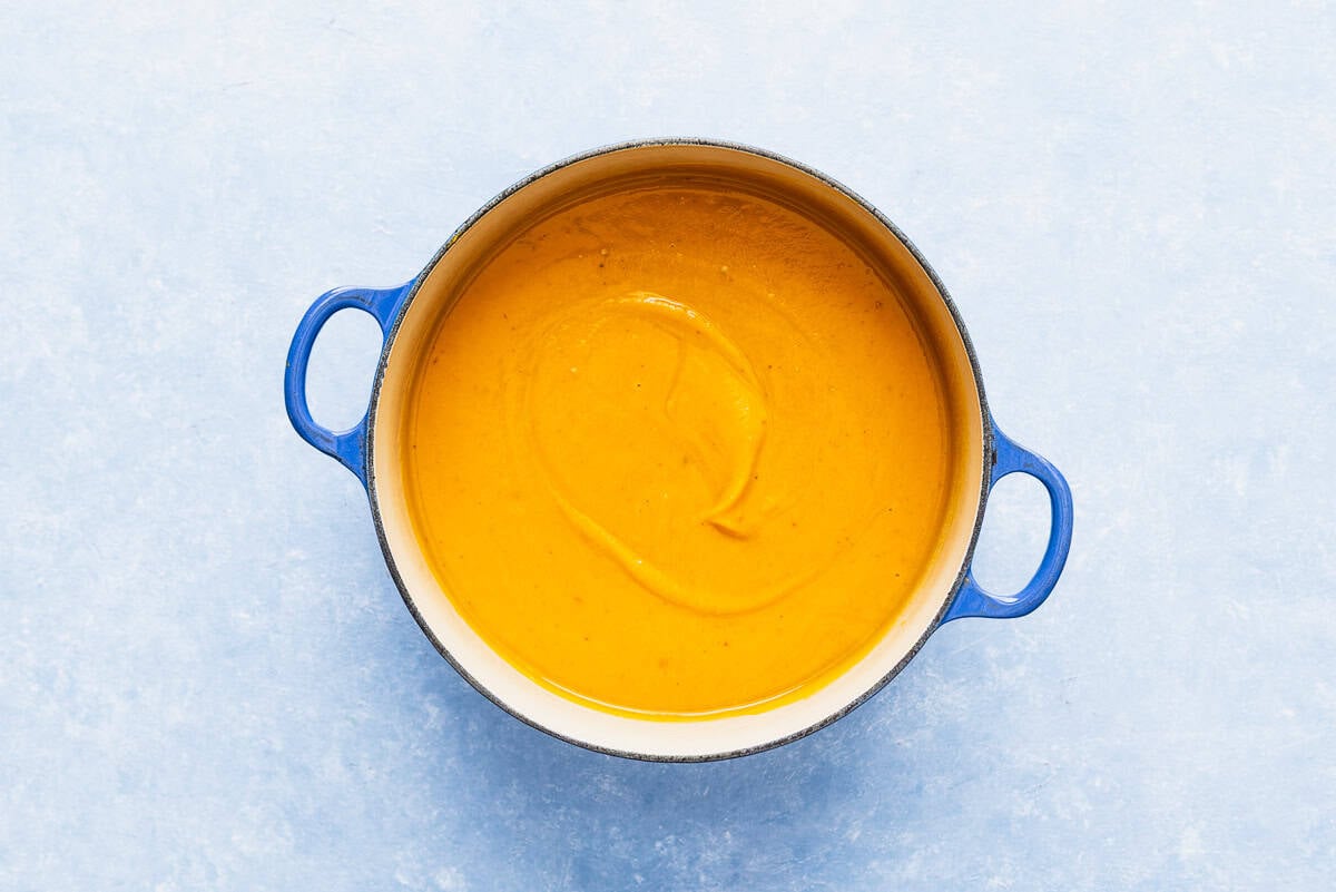The blended pumpkin soup in a large pot.