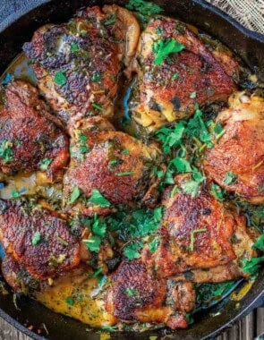 Overhead shot of cilantro lime chicken thighs in a cast iron skillet.
