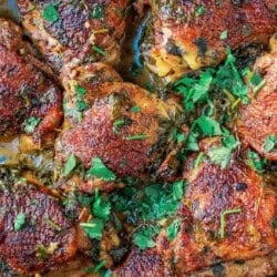 Overhead shot of cilantro lime chicken thighs in a cast iron skillet with fresh cilantro on top.