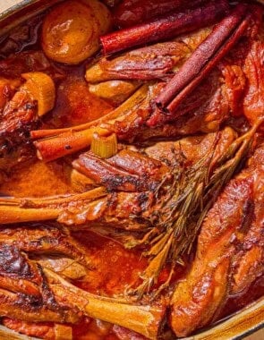 The braised lamb shanks in a large pot.