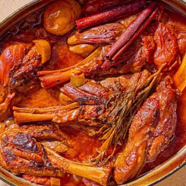 The braised lamb shanks in a large pot.