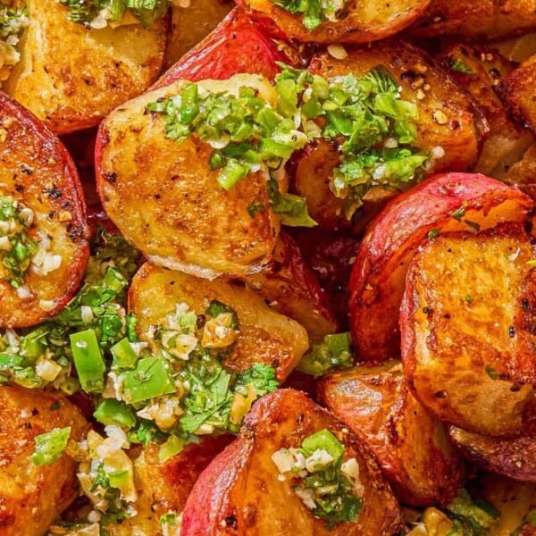 A close up of crispy red skinned potatoes drizzled with walnut cilantro chili sauce.