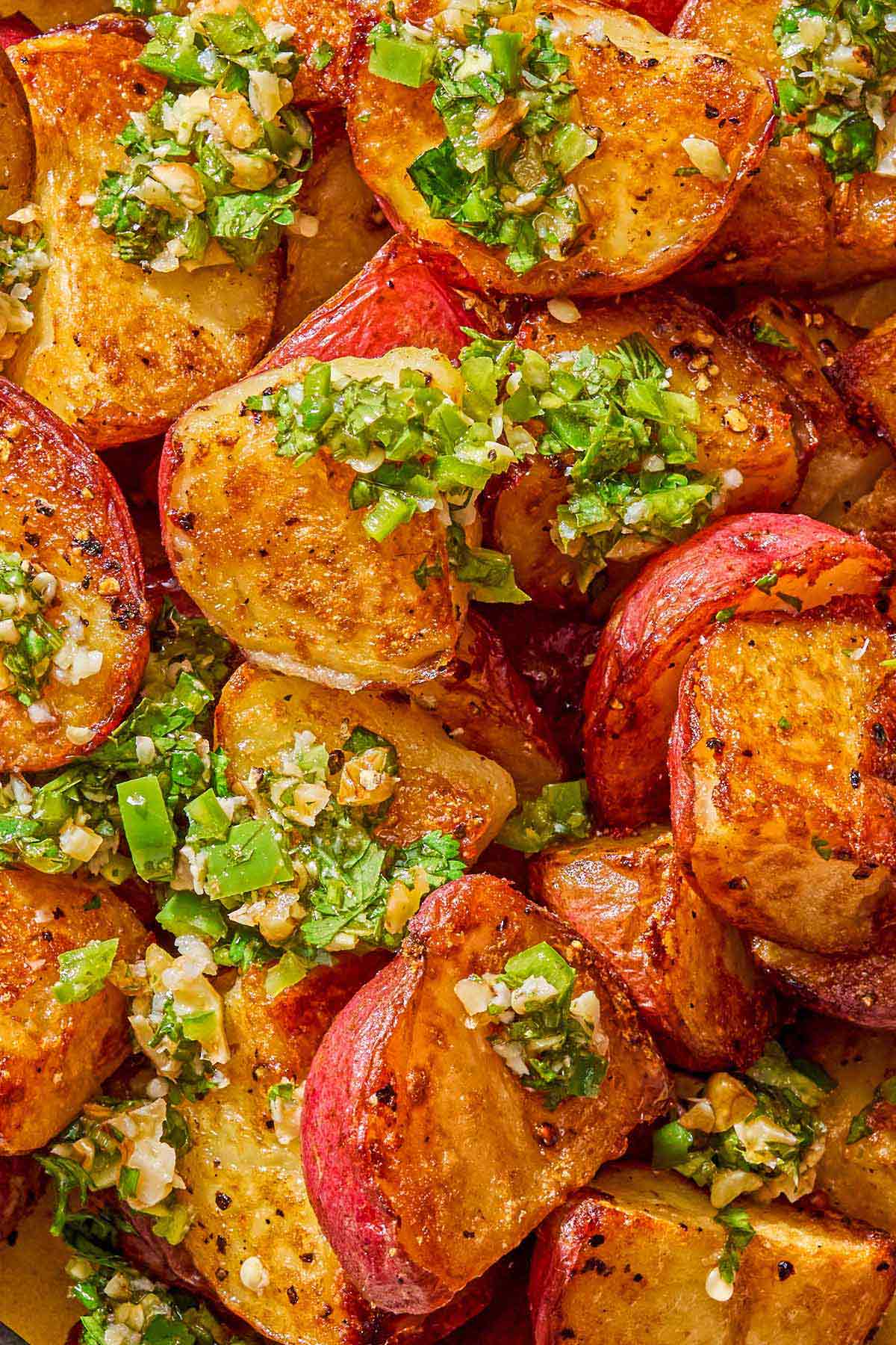 A close up of crispy red skinned potatoes drizzled with walnut cilantro chili sauce.
