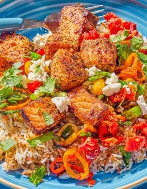 A close up photo of a salmon bowl with a fork.