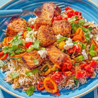 A close up photo of a salmon bowl with a fork.