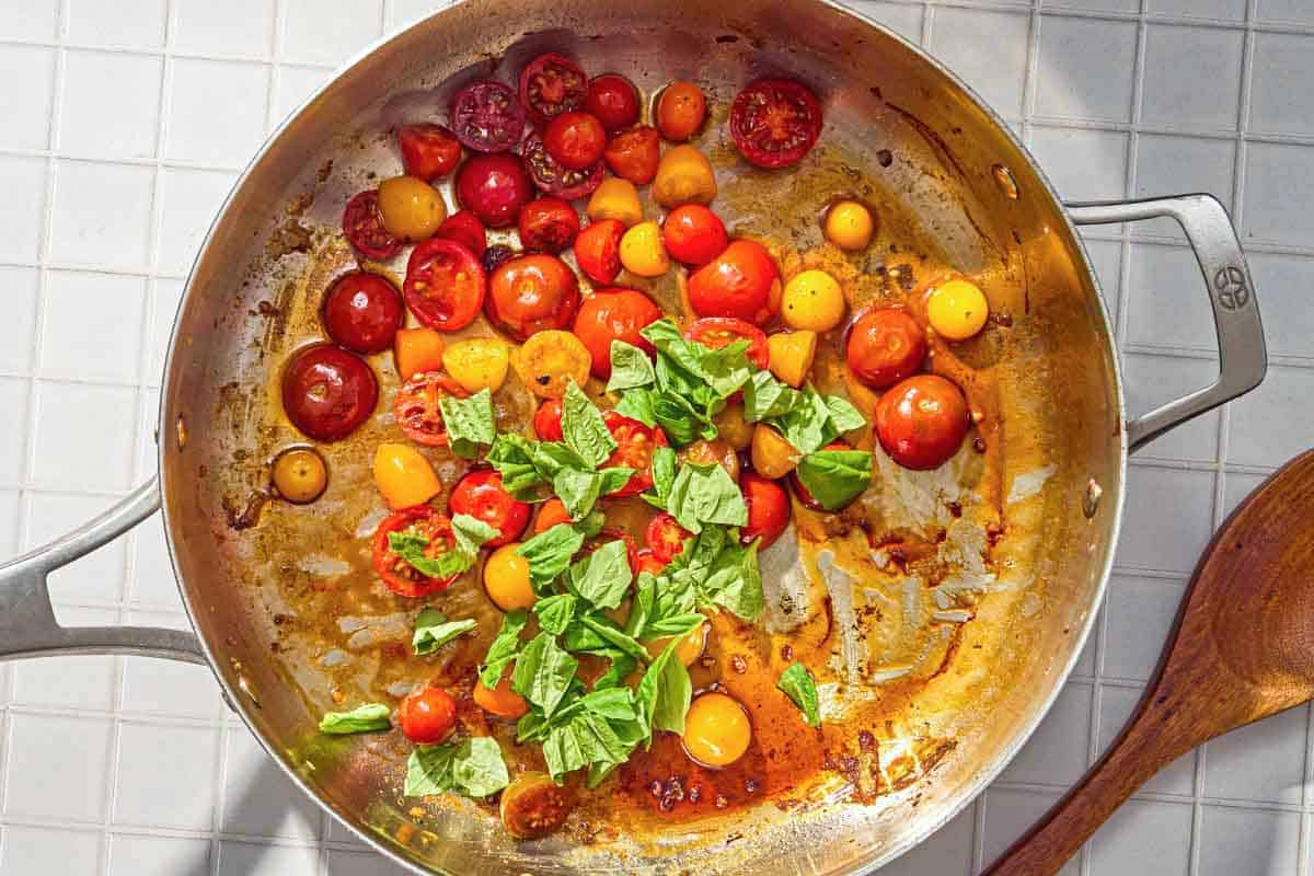 The veggie topping for the savory french toast cooking in a skillet. Next to this is a wooden spoon.