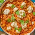 Skillet lasagna in a skillet next sprigs of fresh basil.