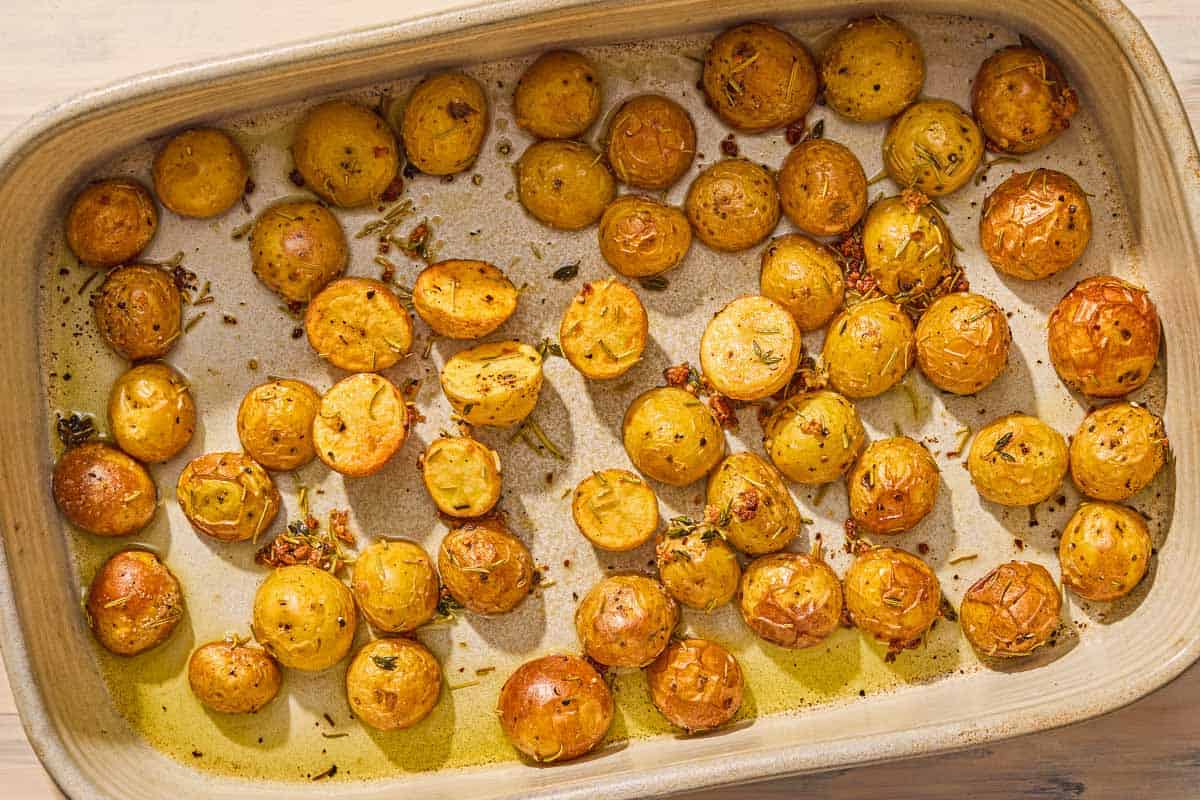 The roasted potatoes for the slow roasted salmon recipe in a baking dish.