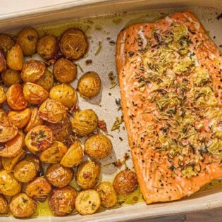 The slow roasted salmon and potatoes in a baking dish.