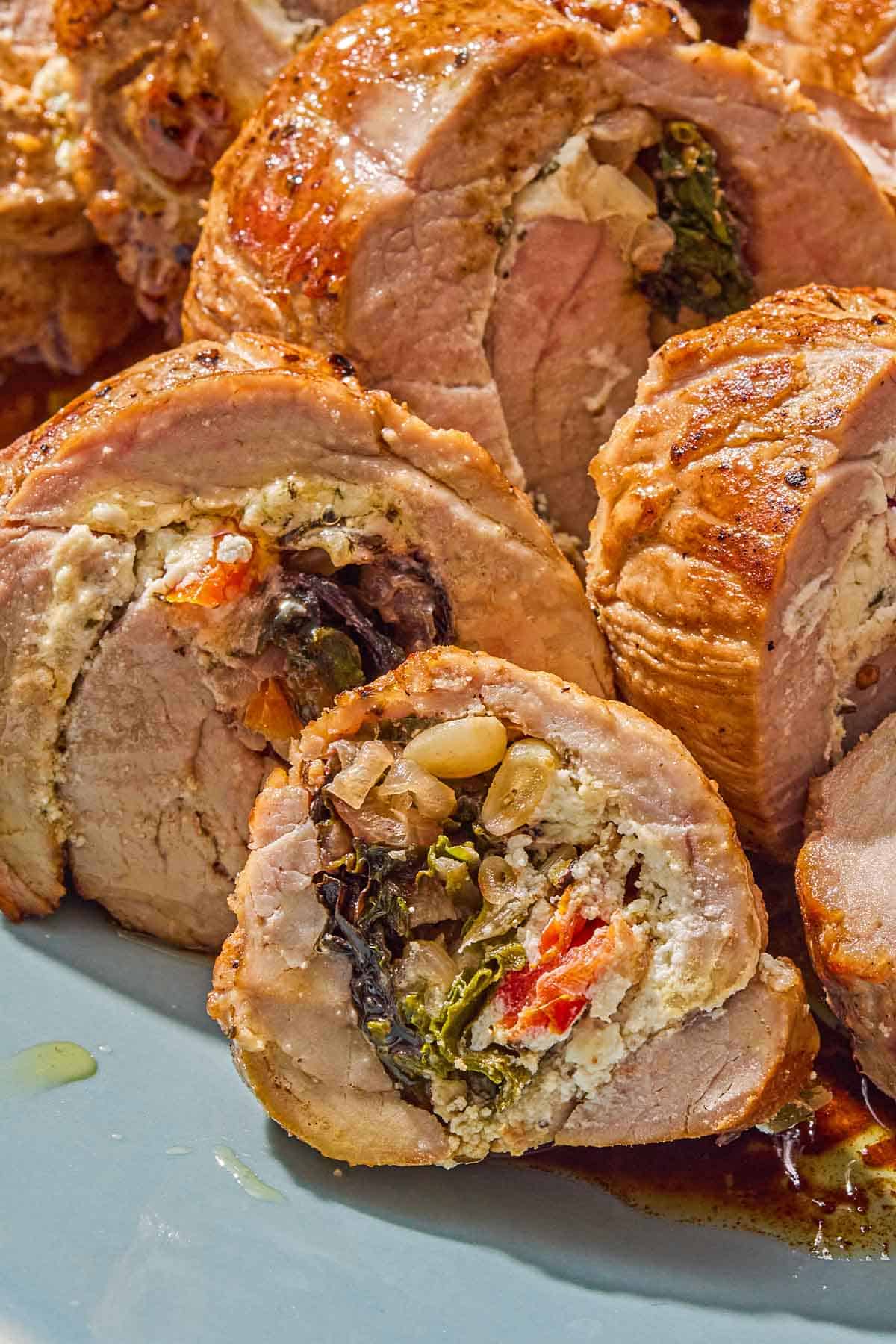 A close up of several slices of the stuffed pork tenderloin.